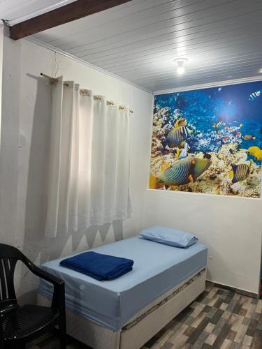 a bed in a room with a painting on the wall at Hospedaria Gaúcha in Penha