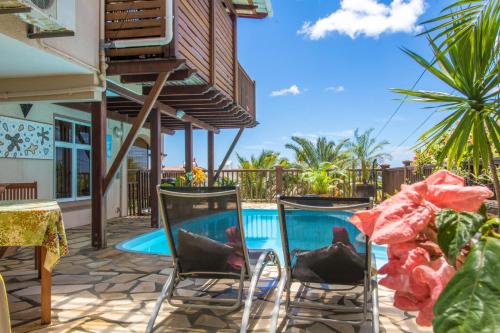 a patio with two chairs and a swimming pool at Blue Lagoon Villa in La Gaulette