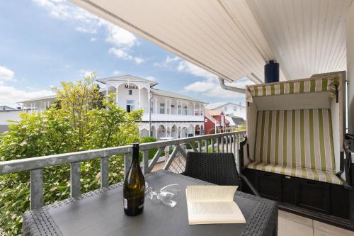 a bottle of wine sitting on a table on a balcony at Ferienwohnung "Ostseewind" - Bade- & Saunawelt täglich inklusive in Göhren