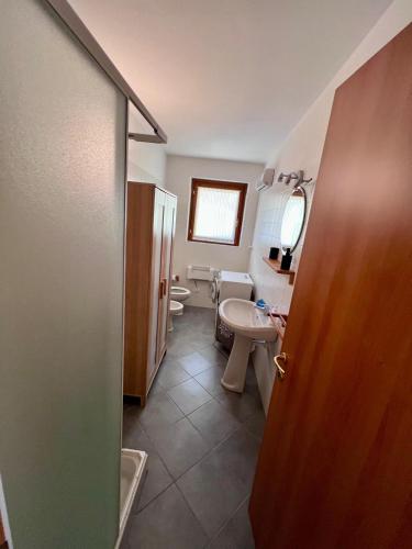 a bathroom with a toilet and a sink and a mirror at Appartamento Orchidea in Lepreno