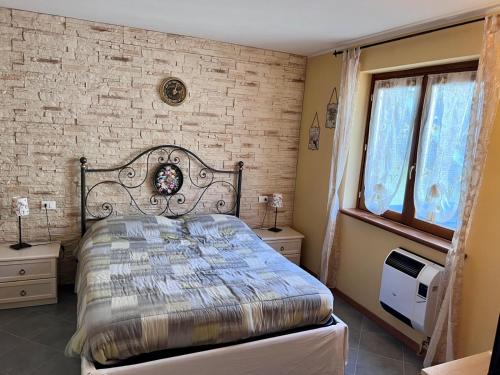 a bedroom with a bed and a brick wall at Appartamento Orchidea in Lepreno