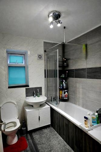 a bathroom with a toilet and a sink and a tub at The Peaceful Home in Nottingham