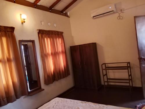 a bedroom with a bed and a mirror and a window at The Home in Weligama