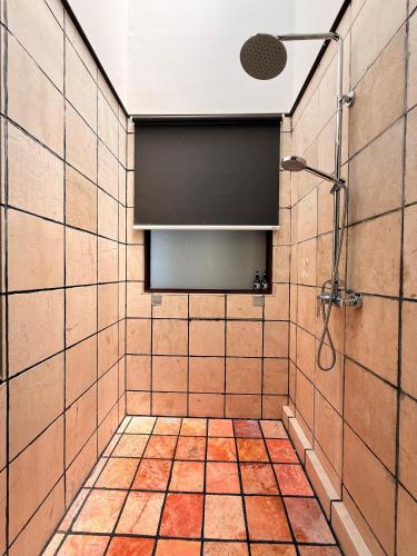a bathroom with a shower and a tiled wall at PD Full Seaview Water Chalet with Private Bathtub in Port Dickson