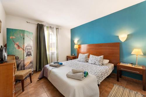 a bedroom with a bed and a blue wall at The Colors House, 639 Private Apartment in Costa Teguise