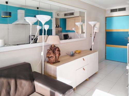a living room with a chair and a desk with a lamp at Appartement Cap Hermès in Fréjus