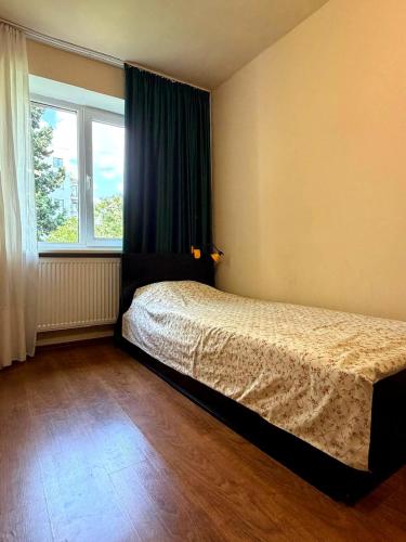 a bedroom with a bed in front of a window at Tbilisi Vake Inn in Tbilisi City