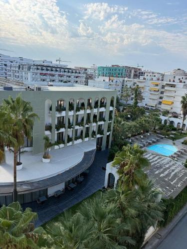 arial view of a building with a pool and palm trees at Almare ApartHotel in Golem