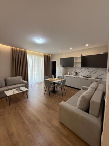 a living room with a couch and a table and a kitchen at Almare ApartHotel in Golem