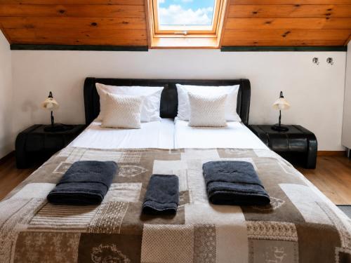 a bedroom with a large bed with towels on it at Nánaháza in Alsónána