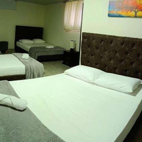 a hotel room with two beds and a headboard at Parque de la Familia in Montenegro