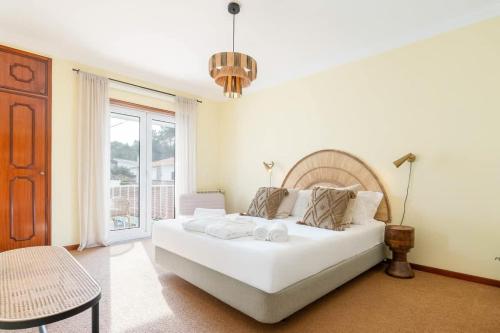 a bedroom with a large white bed and a window at Portugal Active Cabedelo Beach Lodge - Heated Pool in Viana do Castelo