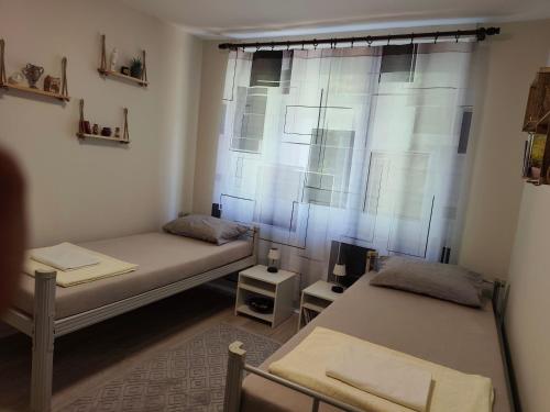 two beds in a room with a window at My Way in Beograd