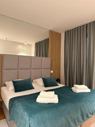 a bedroom with a large bed with towels on it at REGENTova SUITES Ljubljana in Ljubljana