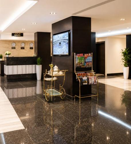 a lobby with a tv on the wall and a cart at توارن للشقق المخدومة اقتصادي in Al Khobar