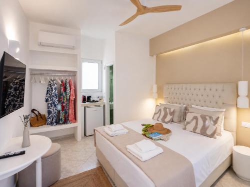 a bedroom with a large white bed and a desk at Mania Rooms and Studios in Poros