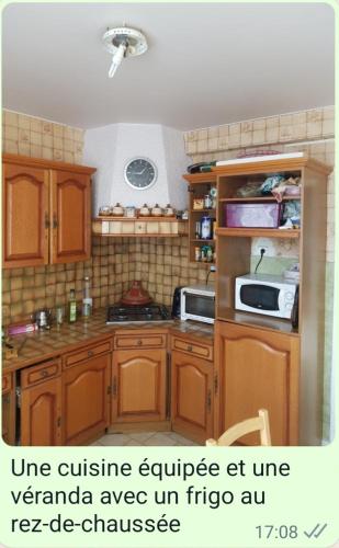 a kitchen with wooden cabinets and a microwave at Chambre Simple avec parking gratuit in Bourges