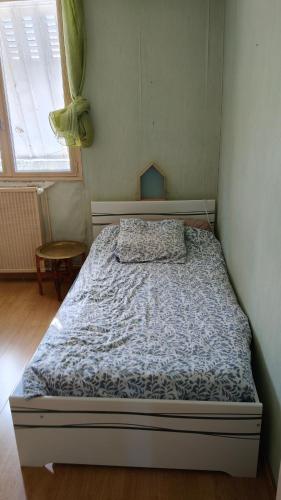 a bedroom with a bed with a blue comforter at Chambre Simple avec parking gratuit in Bourges