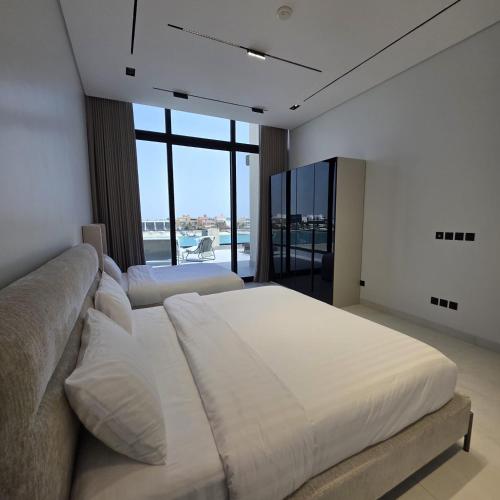 a bedroom with a large bed and a large window at ViLora VILA in Durat Alarous