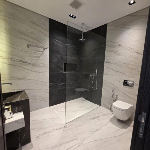a bathroom with a shower and a toilet and a sink at ViLora VILA in Durat Alarous