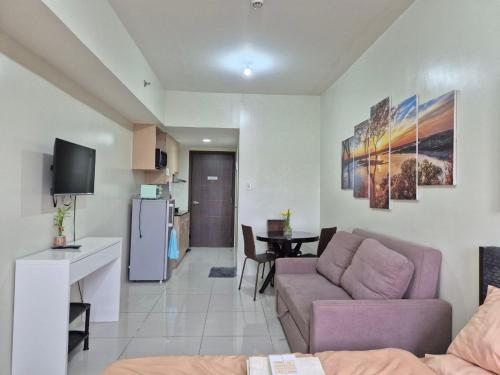a living room with a couch and a table and a kitchen at CozyNest Rentals at Brenthill Condominium in Baguio
