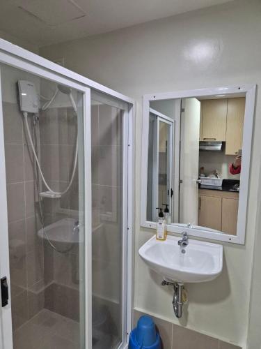 a bathroom with a sink and a shower at CozyNest Rentals at Brenthill Condominium in Baguio
