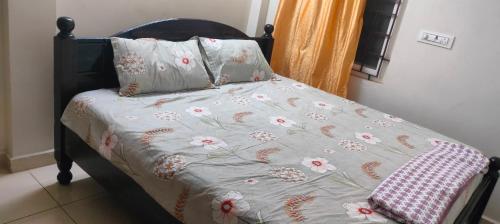 a bed with a comforter with flowers on it at Sri varahi rest house in Avanigadda