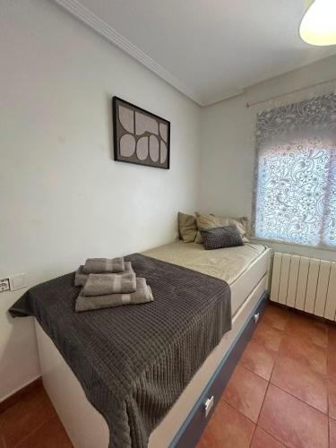 a bedroom with a bed and a window at Chalet Los angeles torrevieja in Torrevieja