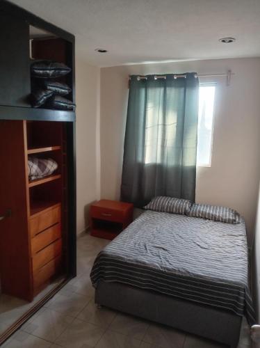 a bedroom with a bed with a blue curtain at Santa Rosalía3- 2 habitaciones in San Felipe Hueyotlipan