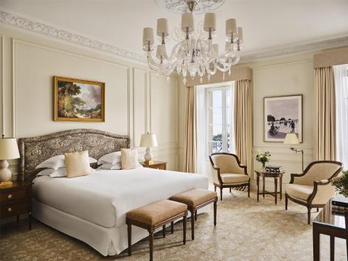 a bedroom with a large white bed and a chandelier at Hôtel du Palais Biarritz, in The Unbound Collection by Hyatt in Biarritz