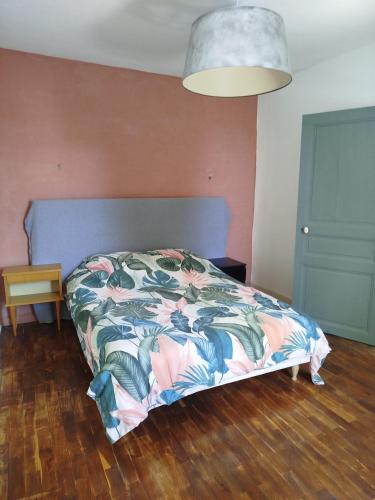 a bedroom with a bed with a colorful comforter at Les lilas in Moëlan-sur-Mer