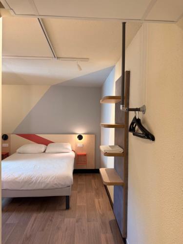 a bedroom with a bed and a book shelf at ibis budget Brive La Gaillarde in Brive-la-Gaillarde