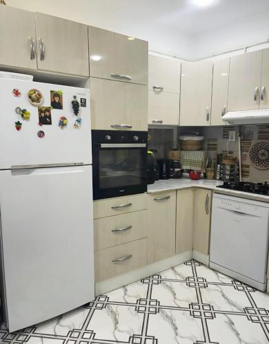 a kitchen with white appliances and white cabinets at Apartment - Jijel in Jijel