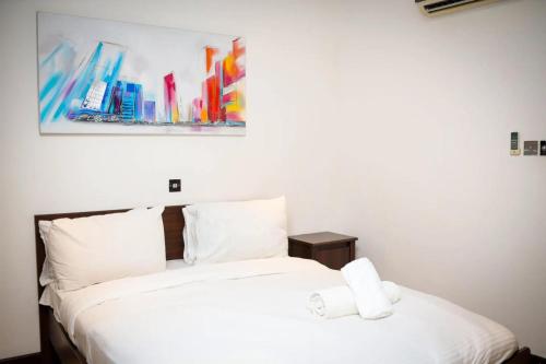 a bedroom with two beds and a painting on the wall at Premier Place, Sky Suites in Accra