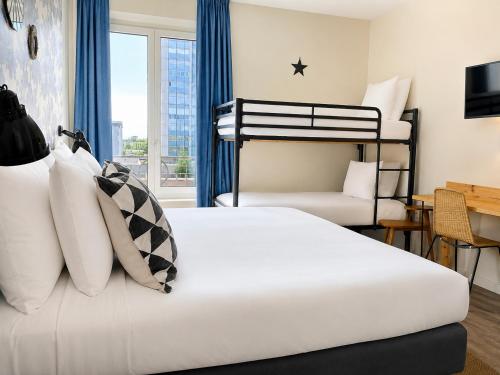 a bedroom with two bunk beds and a desk at Hôtel Stanley by HappyCulture in Nancy