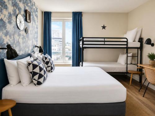 a bedroom with two bunk beds and a table at Hôtel Stanley by HappyCulture in Nancy