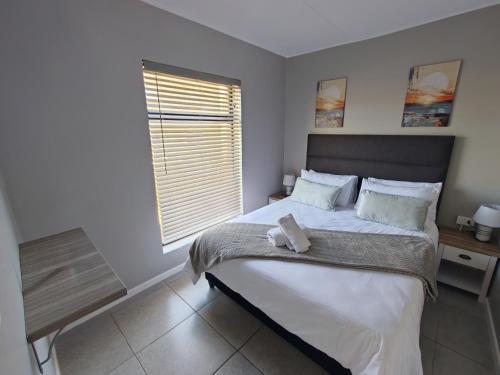 a bedroom with a large bed and a window at 19 on Arch in Langebaan