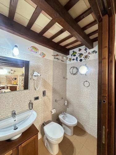 a bathroom with a sink and a toilet and a mirror at Casa Claudia Stagnone in Marsala