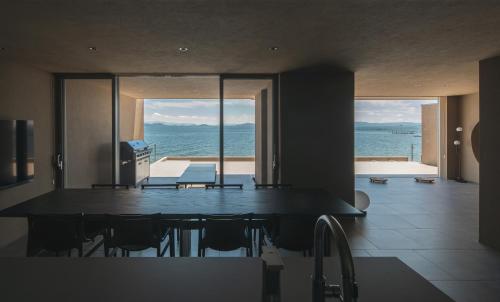a dining room with a table and a view of the ocean at ENINARU East in Otsu