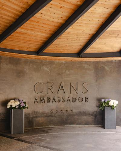 a wall with the genes ambassador sign on it at Crans Ambassador in Crans-Montana