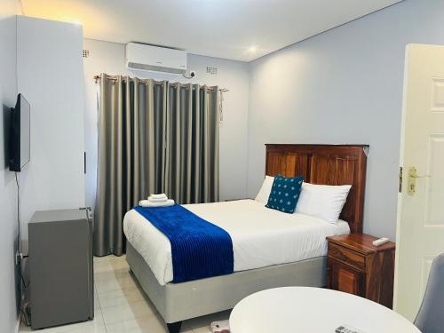 a small bedroom with a bed and a window at Brooke Paradise in Bulawayo