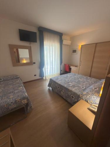 a hotel room with two beds and a window at Hotel Grotte in Mongiove