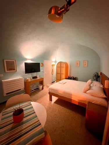 a bedroom with a bed and a desk and a television at Ca' Letizia in Noli