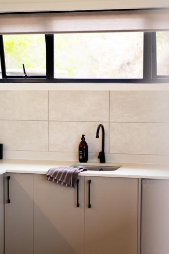 a kitchen counter with a sink and a window at Springsteen Cabins in Tulbagh