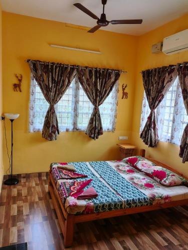 a bedroom with a bed and two windows at Clintons Cove in Cochin