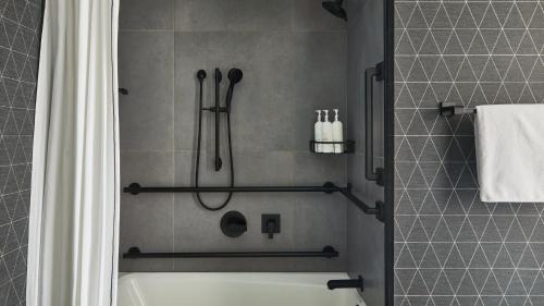ein Badezimmer mit Dusche mit Badewanne und Duschvorhang in der Unterkunft Kimpton Marlowe by IHG in Cambridge