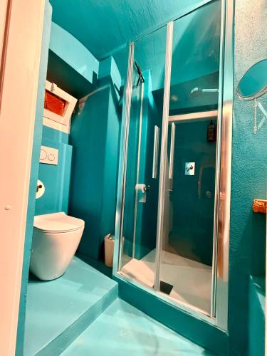 a blue bathroom with a toilet and a glass shower at Ca' Letizia in Noli