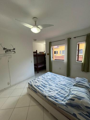 a bedroom with a bed and a ceiling fan at Casas Arraial in Arraial do Cabo