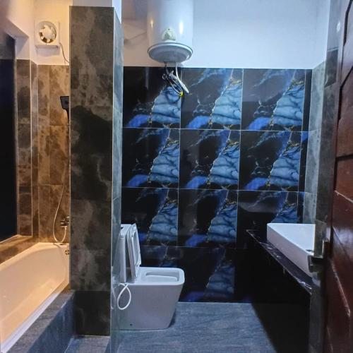 a bathroom with a toilet and a sink and a tub at Aurora White Bungalow Kandy in Kandy
