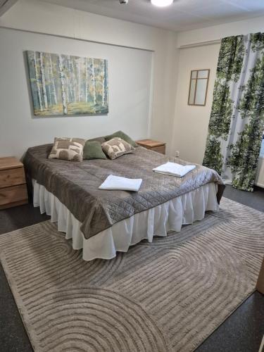 a bedroom with a large bed with two pillows on it at Koivutie Best rooms in Ranua